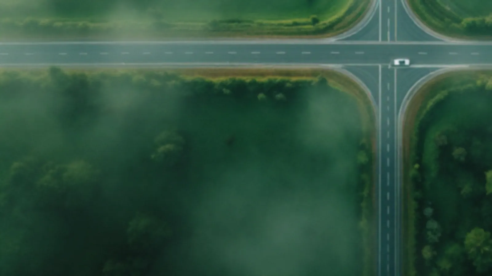 Aerial view of two empty roads meeting in a green valley in morning mist, the MileageQuote view of loan quotes online, $100 – $5,000